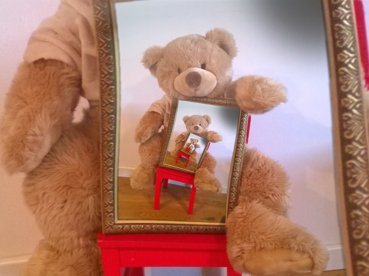 A teddy bear holding a mirror, the reflection repeating into itself and spiralling away to a point.